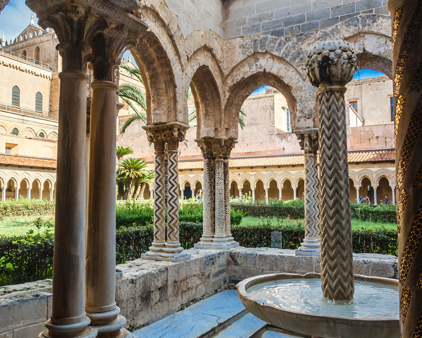 Kreuzgang des Doms von Monreale mit verzierten Säulen, Arkaden und Brunnen