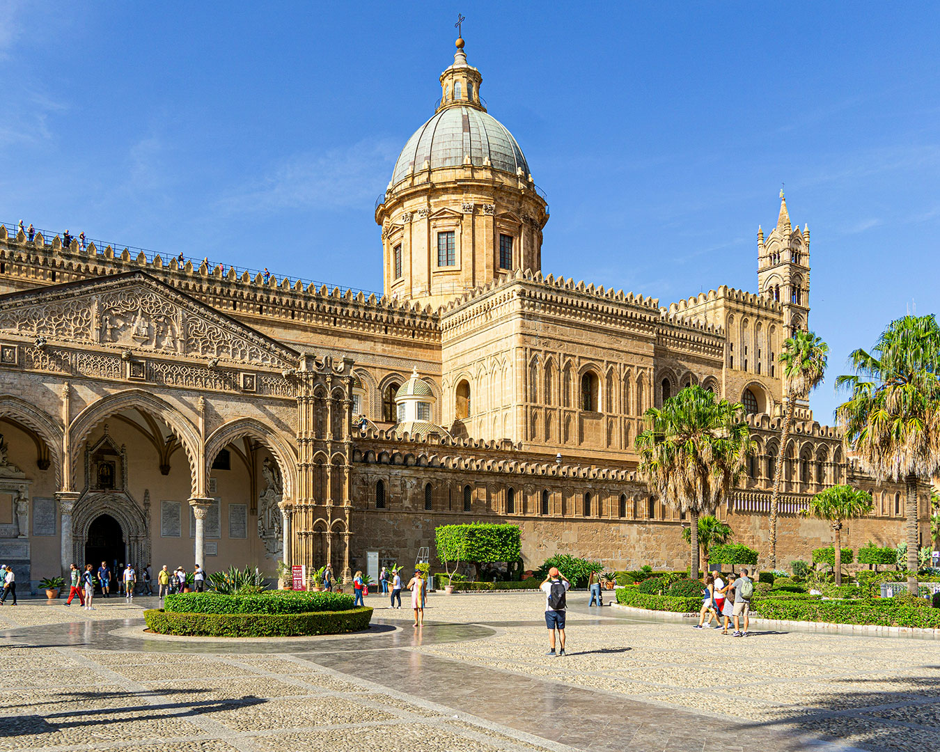 Kathedrale von Palermo mit Kuppel, Türmen und Palmen unter blauem Himmel