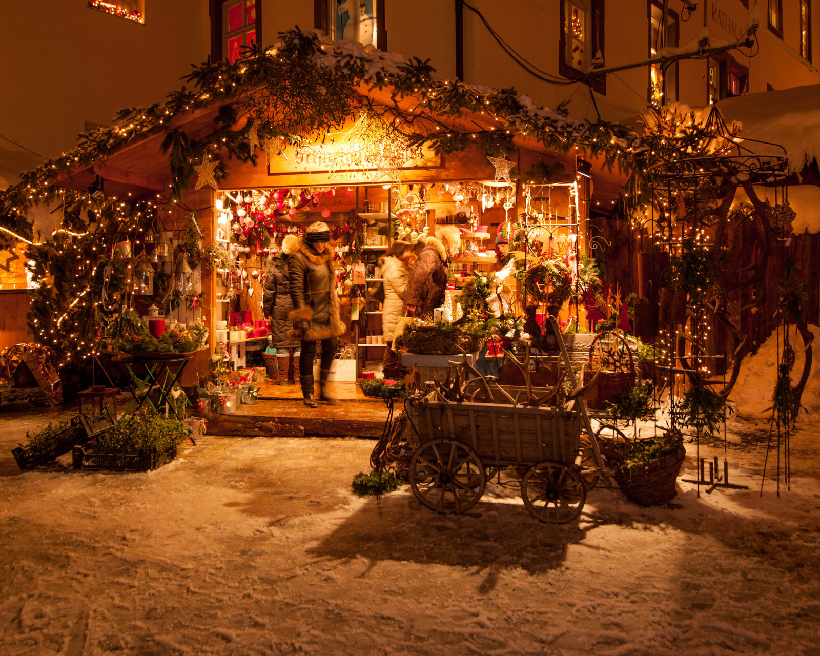 Stimmungsvoll beleuchteter Marktstand mit weihnachtlicher Dekoration und Kunsthandwerk auf dem Bad Hindelang Weihnachtsmarkt