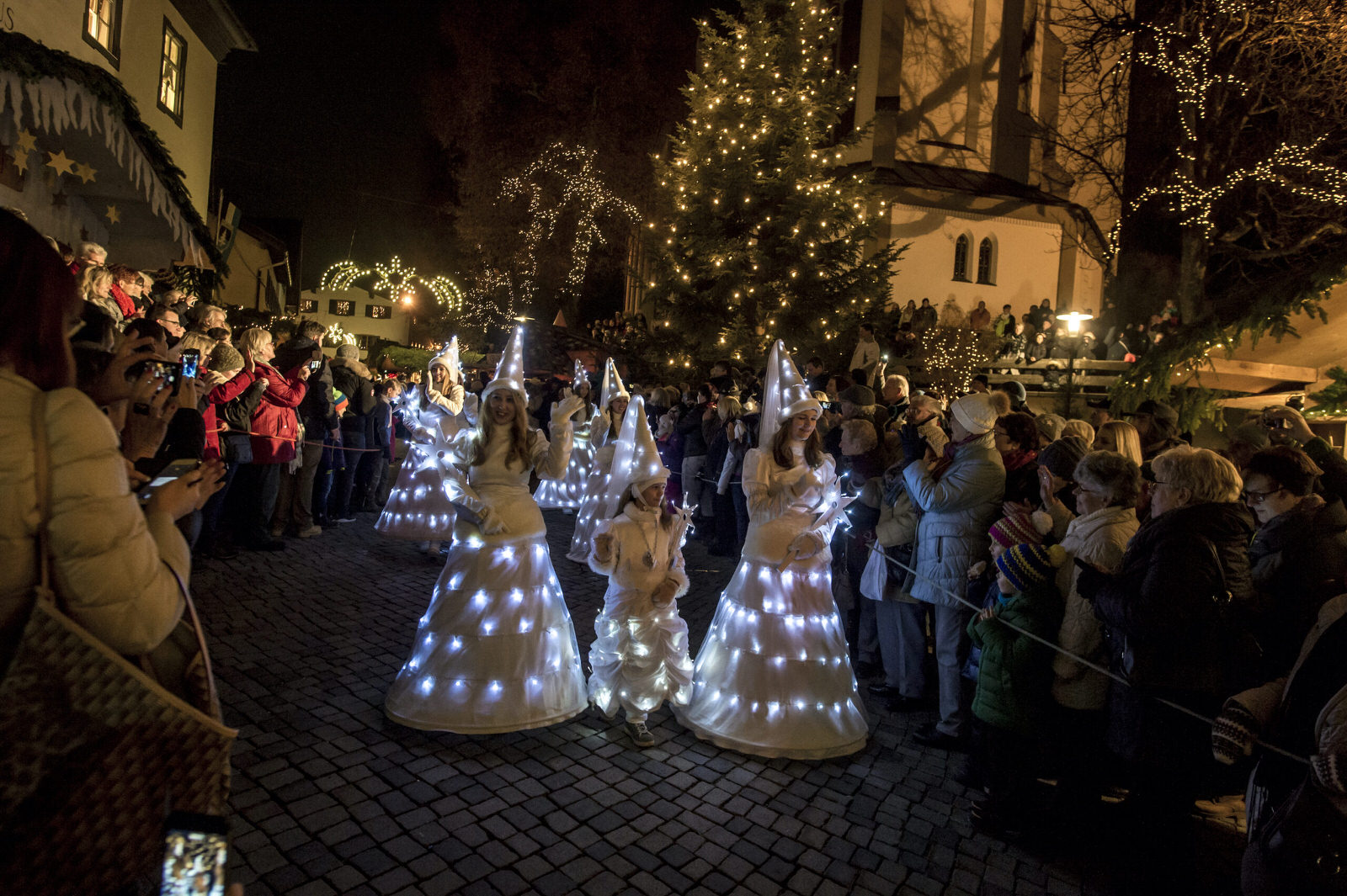 Leuchtende Engel in prachtvollen Lichterkleidern ziehen durch die Gassen des Bad Hindelang Weihnachtsmarkts und verzaubern die Besucher