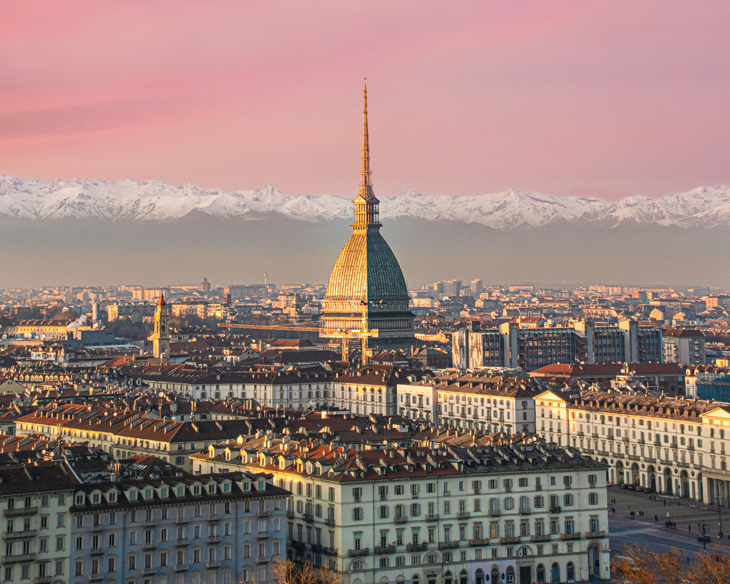 Panoramablick auf Turin mit der Mole Antonelliana und den schneebedeckten Alpen im Hintergrund.