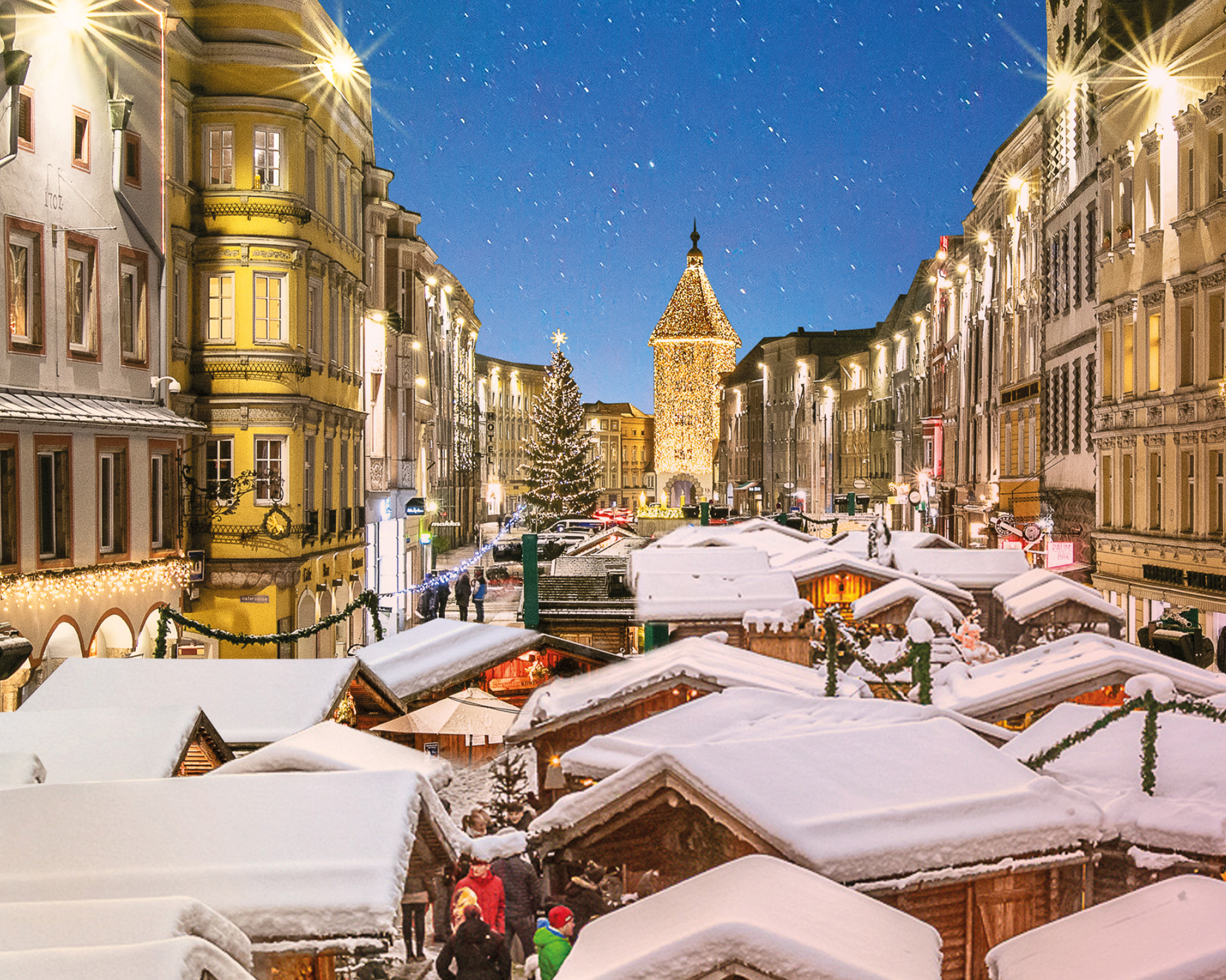 Winterliche Welser Weihnachtswelt mit schneebedeckten Hütten und festlicher Beleuchtung – © Wels Marketing & Touristik GmbH / Rene Hauser