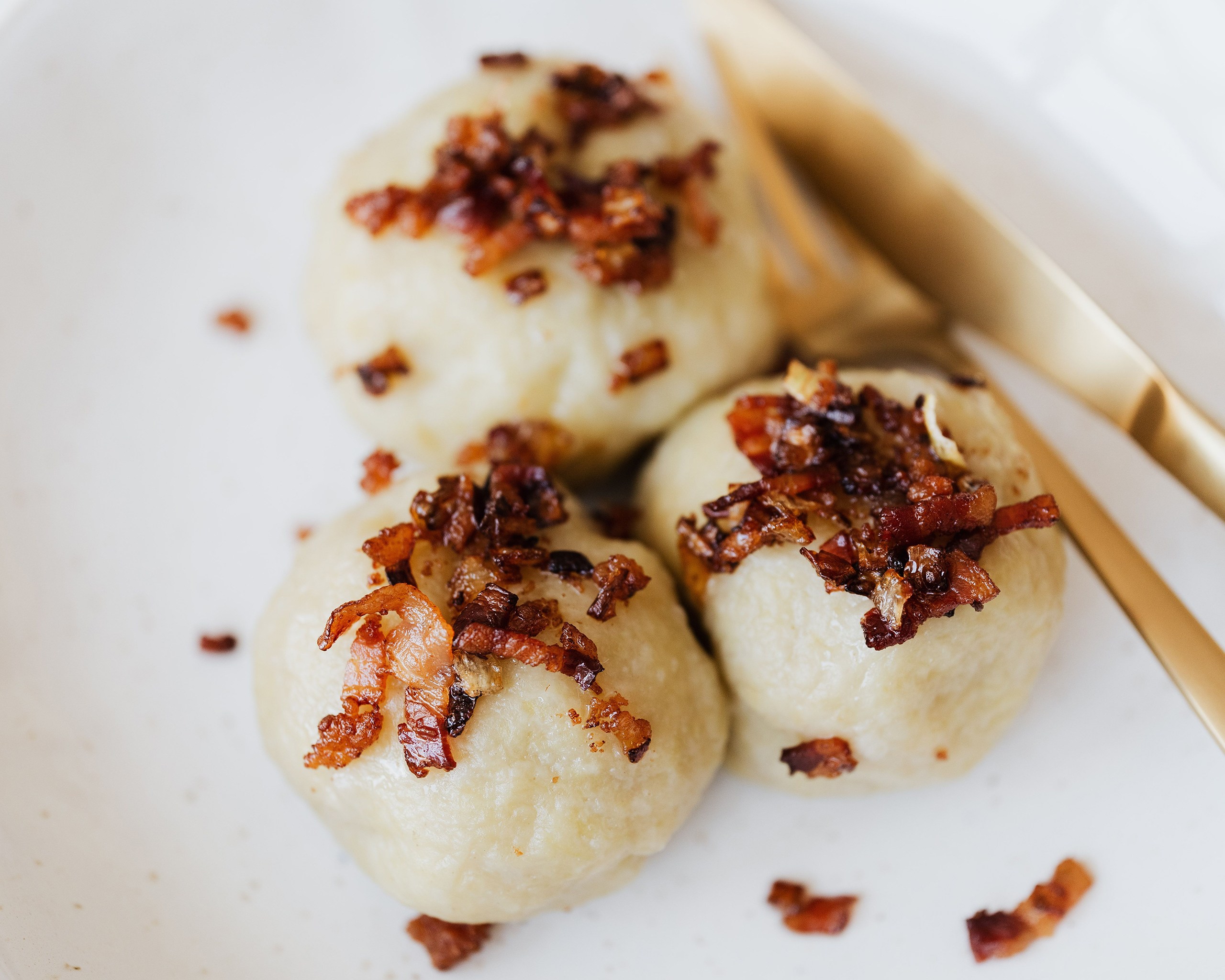 Traditionelle Knödel mit knusprig gebratenem Speck und Zwiebeln als typische Spezialität beim Knödelfest in Sterzing. © Pexels