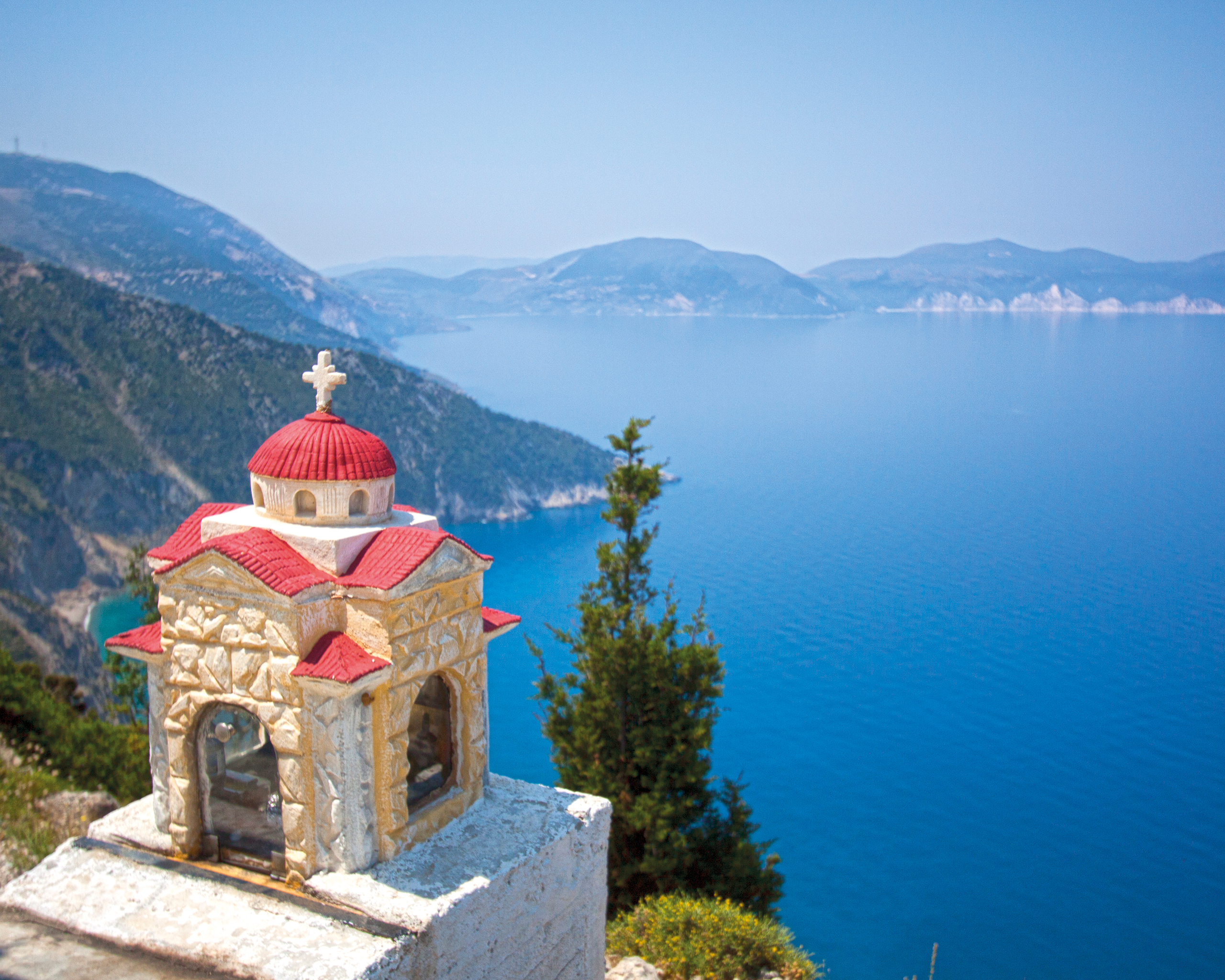 Kapelle mit roter Kuppel bei Assos auf Kefalonia mit Blick auf das tiefblaue Ionische Meer und die umliegenden Berge © Idealtours