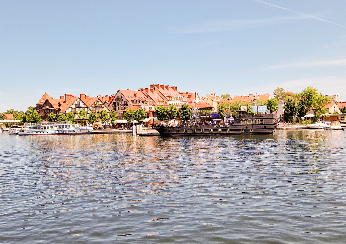 Historisches Hafenviertel mit Ausflugsschiffen und traditionellen Giebelhäusern am Wasser in Masuren.