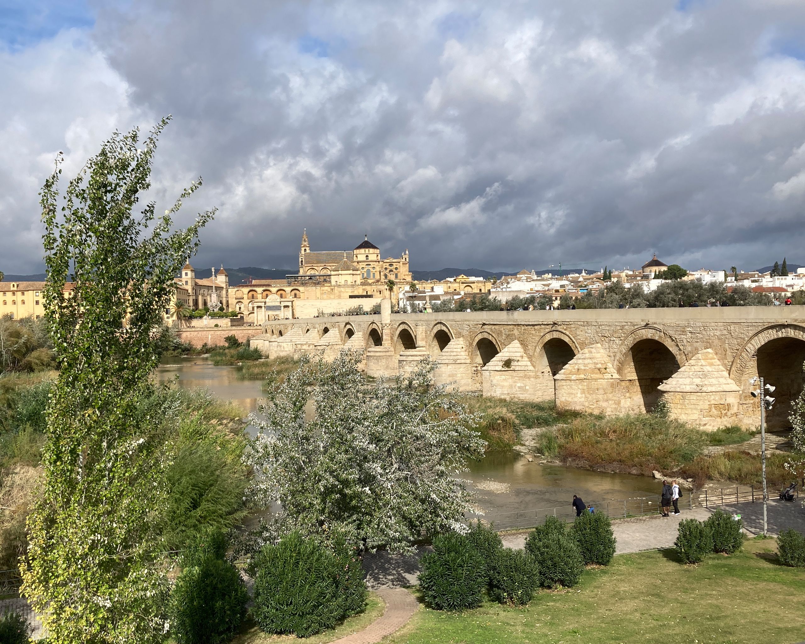 Blick auf die historische Römerbrücke von Córdoba über den Fluss Guadalquivir mit der Mezquita-Kathedrale und der Altstadt im Hintergrund.