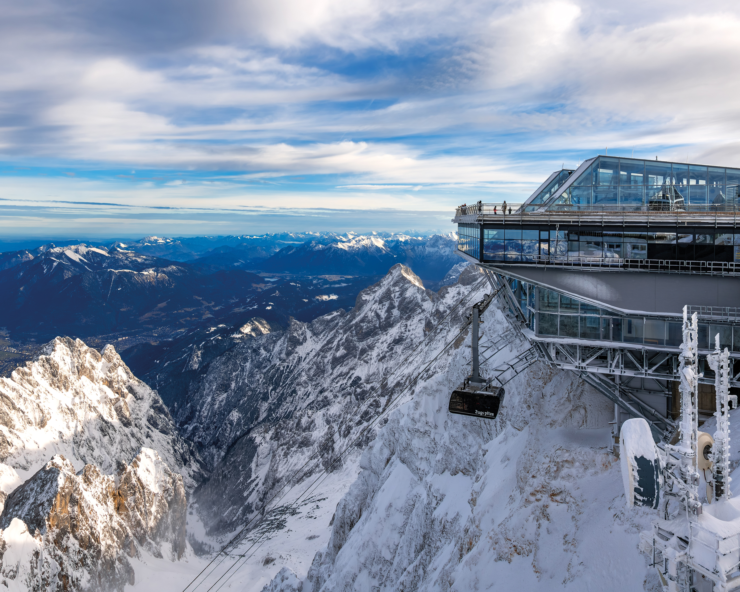 Atemberaubender Ausblick von der Zugspitze mit spektakulärer Aussichtsplattform und schneebedeckten Alpen © Shutterstock