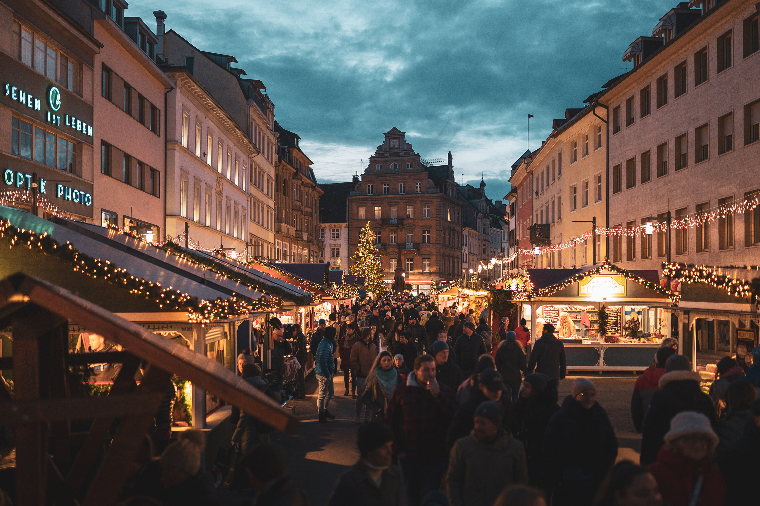 Lebendiger Weihnachtsmarkt in der Altstadt von Konstanz – funkelnde Lichter, duftende Weihnachtshütten und fröhliches Markttreiben