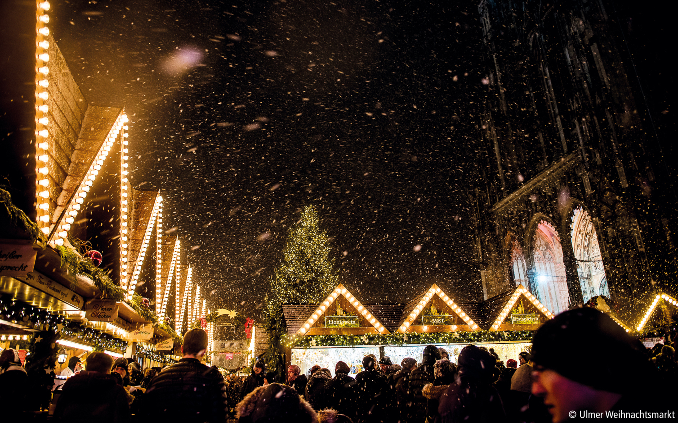 Romantische Winterstimmung: Ulmer Weihnachtsmarkt im Schneegestöber vor dem Ulmer Münster