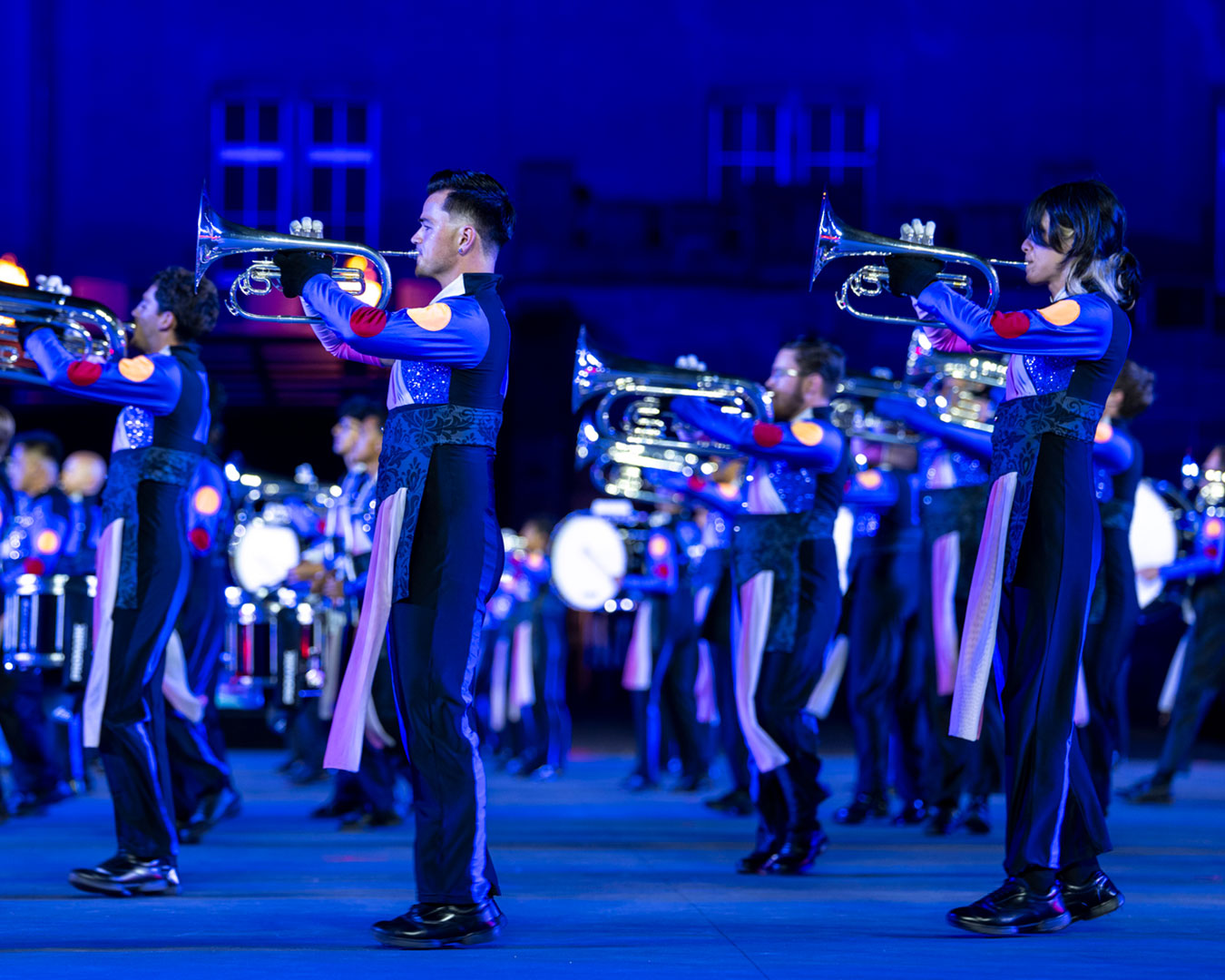 Blasmusik-Formation in blau-schwarzen Uniformen bei einer abendlichen Show des Basel Tattoo
