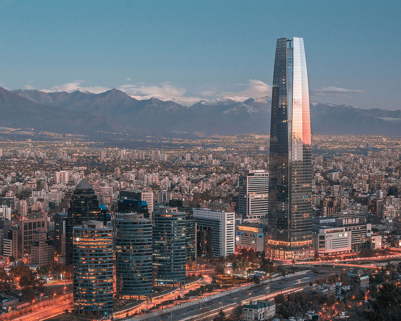 Skyline von Santiago de Chile mit dem modernen Gran Torre Costanera und den schneebedeckten Anden im Hintergrund.