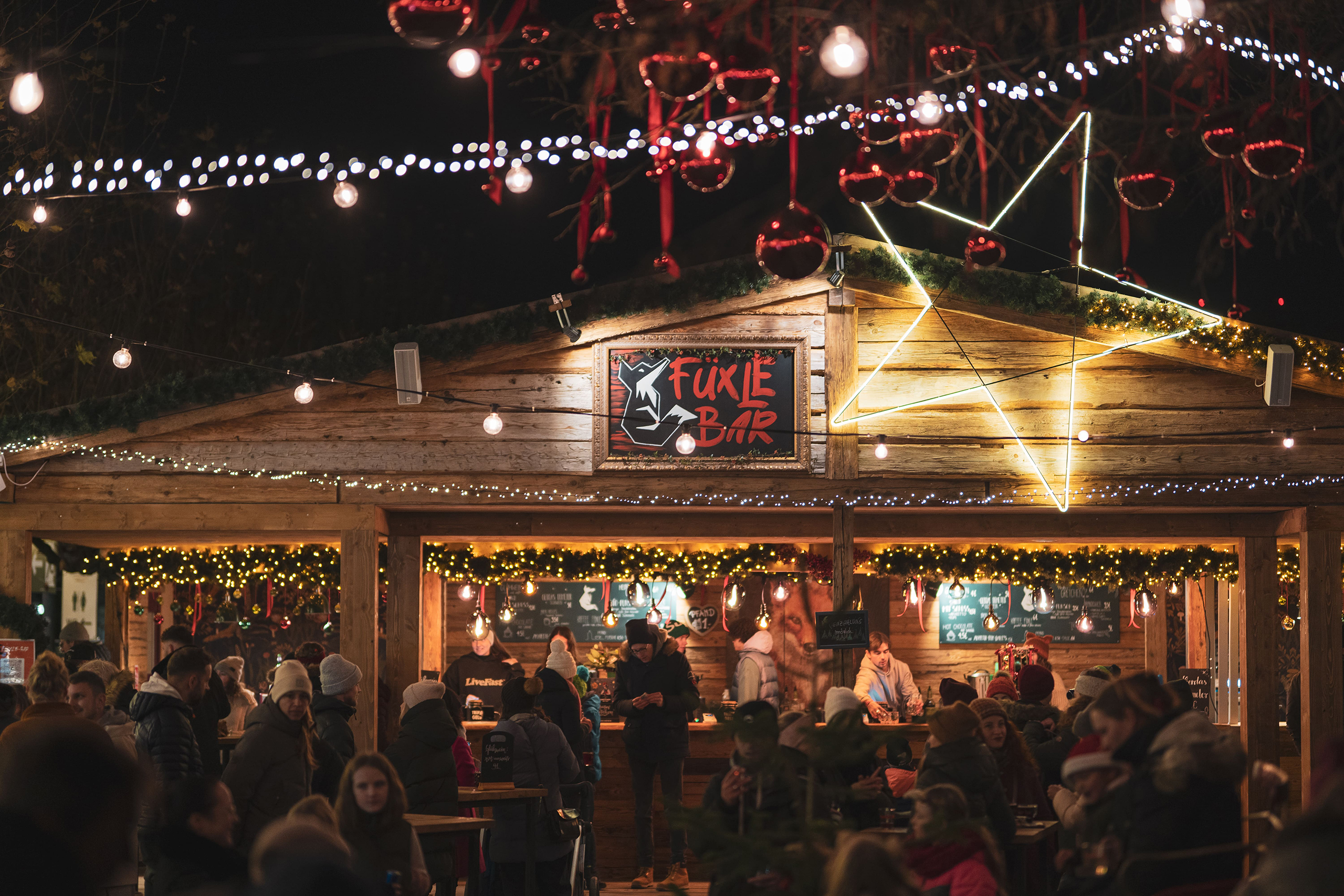 Gesellige Abende auf dem Weihnachtsmarkt Konstanz – stimmungsvolle Fuxle Bar mit leuchtendem Stern und fröhlichem Beisammensein